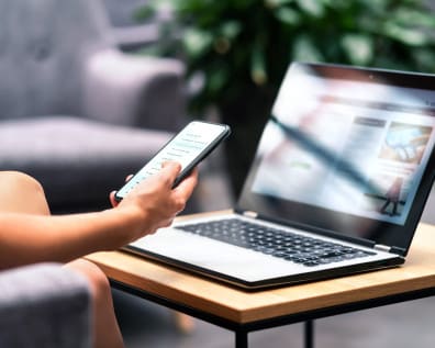 Person using their computer and phone